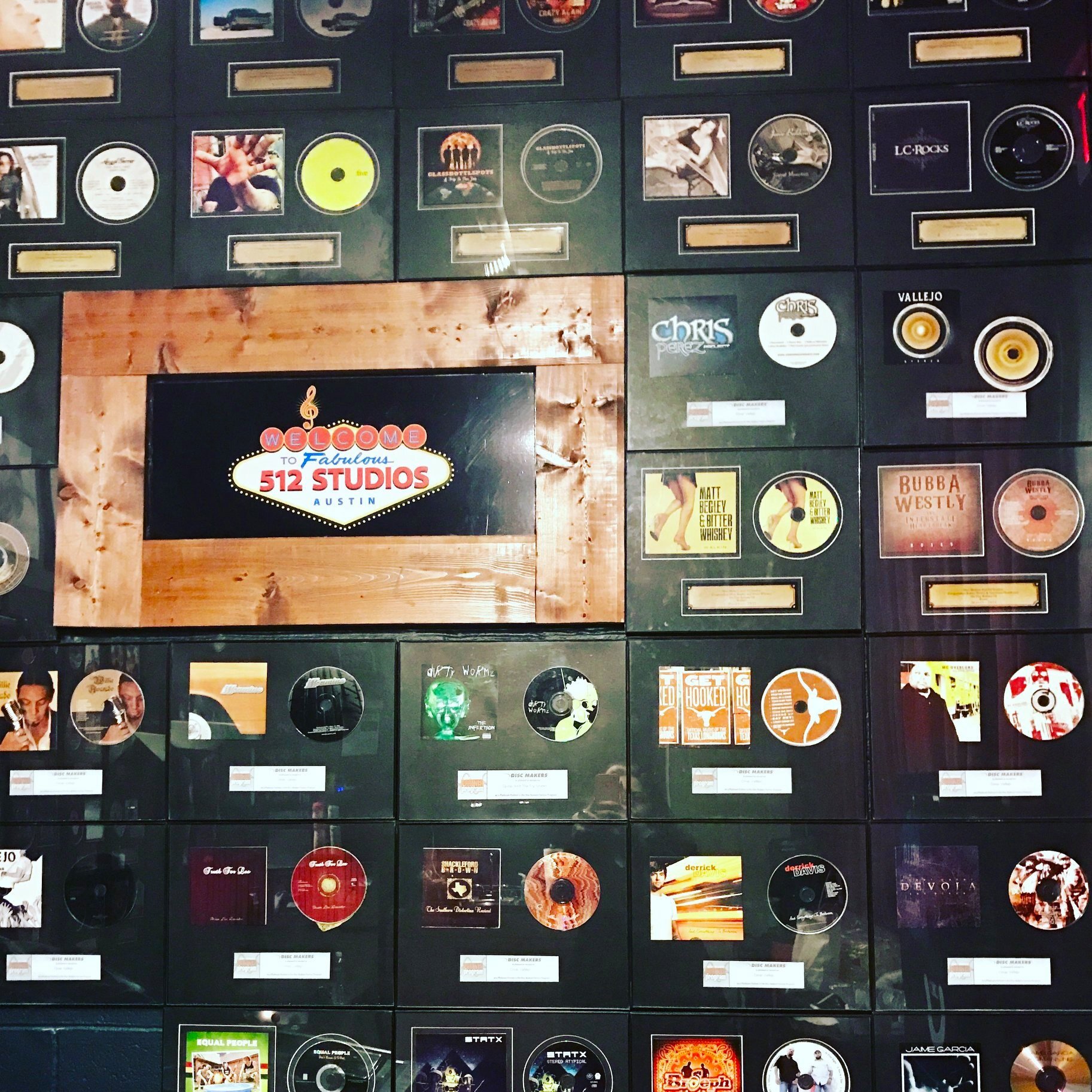 The record wall at 512 Studios with the lit marquee